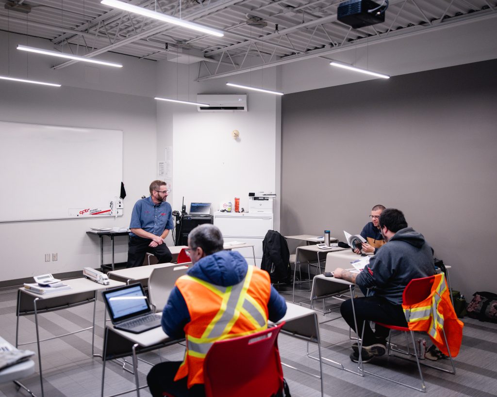 Étudiants en construction dans une classe avec des ordinateurs